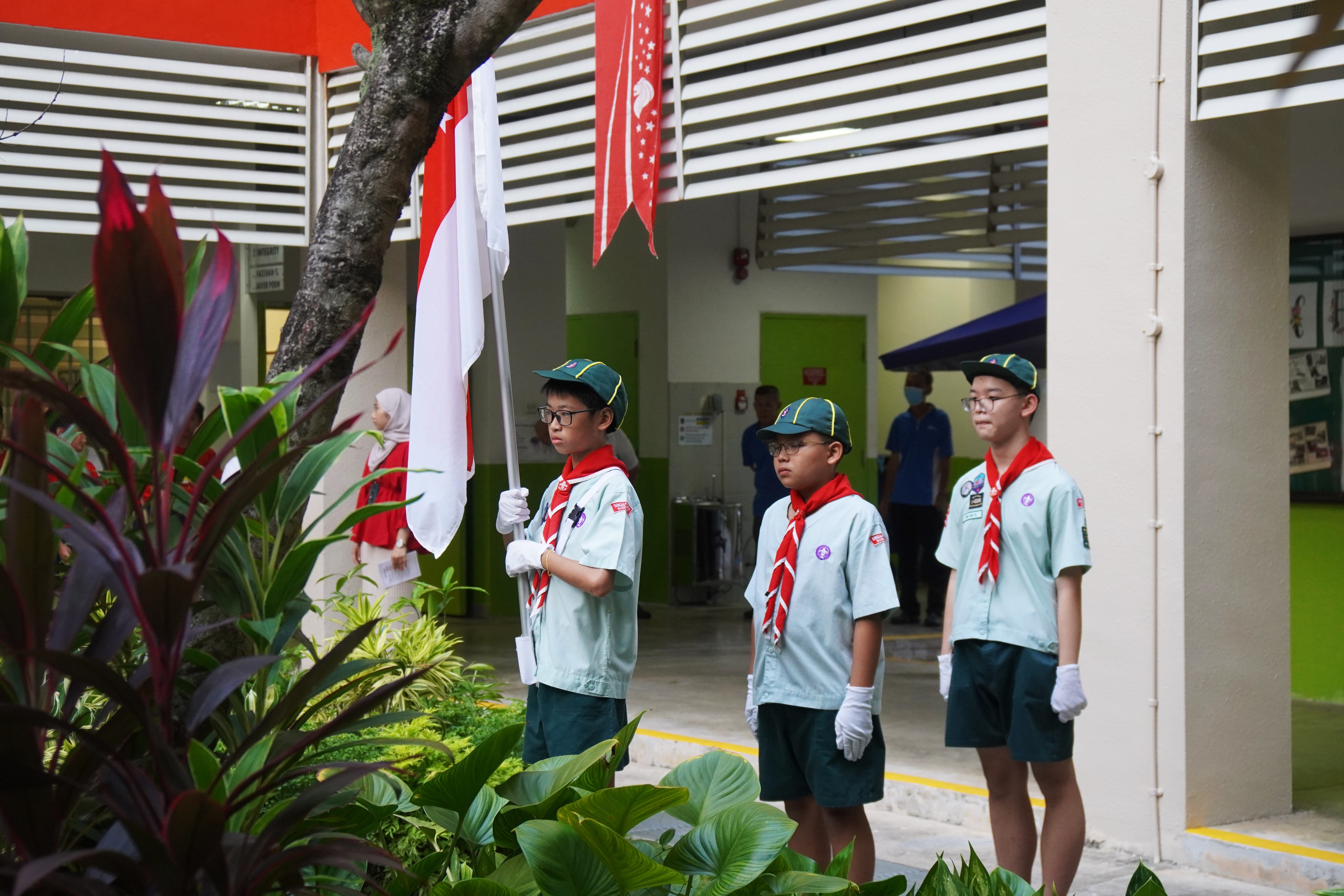 3 students wearing Scouts uniform standing at attention